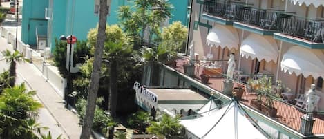 A hotel with a balcony, a street with a stop sign, and a sign for 'Falconera'.