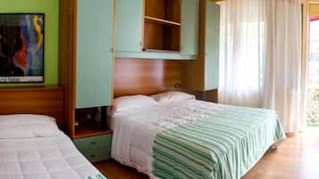 Ein Schlafzimmer mit zwei Betten, einem Holzkopfende, einem grünen Schrank und einem Bild an der Wand.