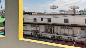 A building with satellite dishes, a balcony with a yellow railing, and a view of the sky. - Jacky Chan Hotel (Betong)