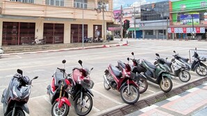 Una hilera de motocicletas estacionadas, un edificio con rejas en las ventanas y un cielo despejado.