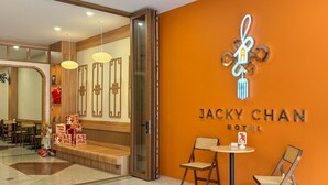 Entrada de hotel con diseño moderno, una recepción y una zona de estar.