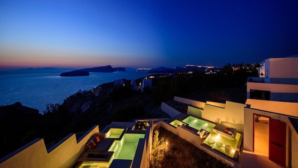A resort with multiple outdoor pools and a view of the sea at dusk. - 11:11 By Potnia Theron - Adults Only (Santorini)