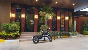 A modern building with a brick facade, large windows, and a motorcycle parked in front.