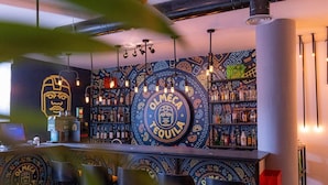 A bar area with a central Olmeca Tequila sign, shelves of liquor bottles, and bar stools. - Boho Boutique Hotel Amman (Amman)