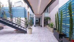 A modern building with a staircase, potted plants, and a blue and white color scheme. - Boho Boutique Hotel Amman (Amman)