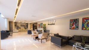 A modern reception area with a sofa, chairs, a coffee table, and a desk. - Boho Boutique Hotel Amman (Amman)