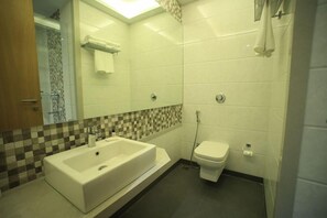 Un baño con lavamanos amplio, inodoro y ducha.