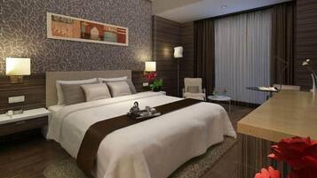 A hotel room with a bed, bedside tables, a desk, and a chair.