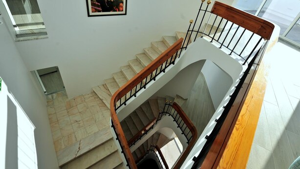 A multi-level interior with a staircase, marble flooring, and a framed photo on the wall. - Hotel Buzio (Sines)