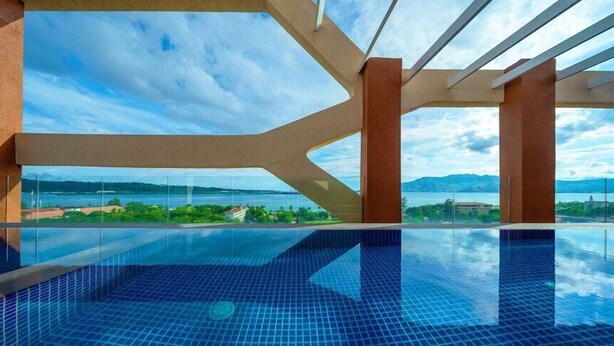 An infinity pool with a clear view of a lake and mountains. - The Aurora Subic Hotel Managed by HII (Olongapo)