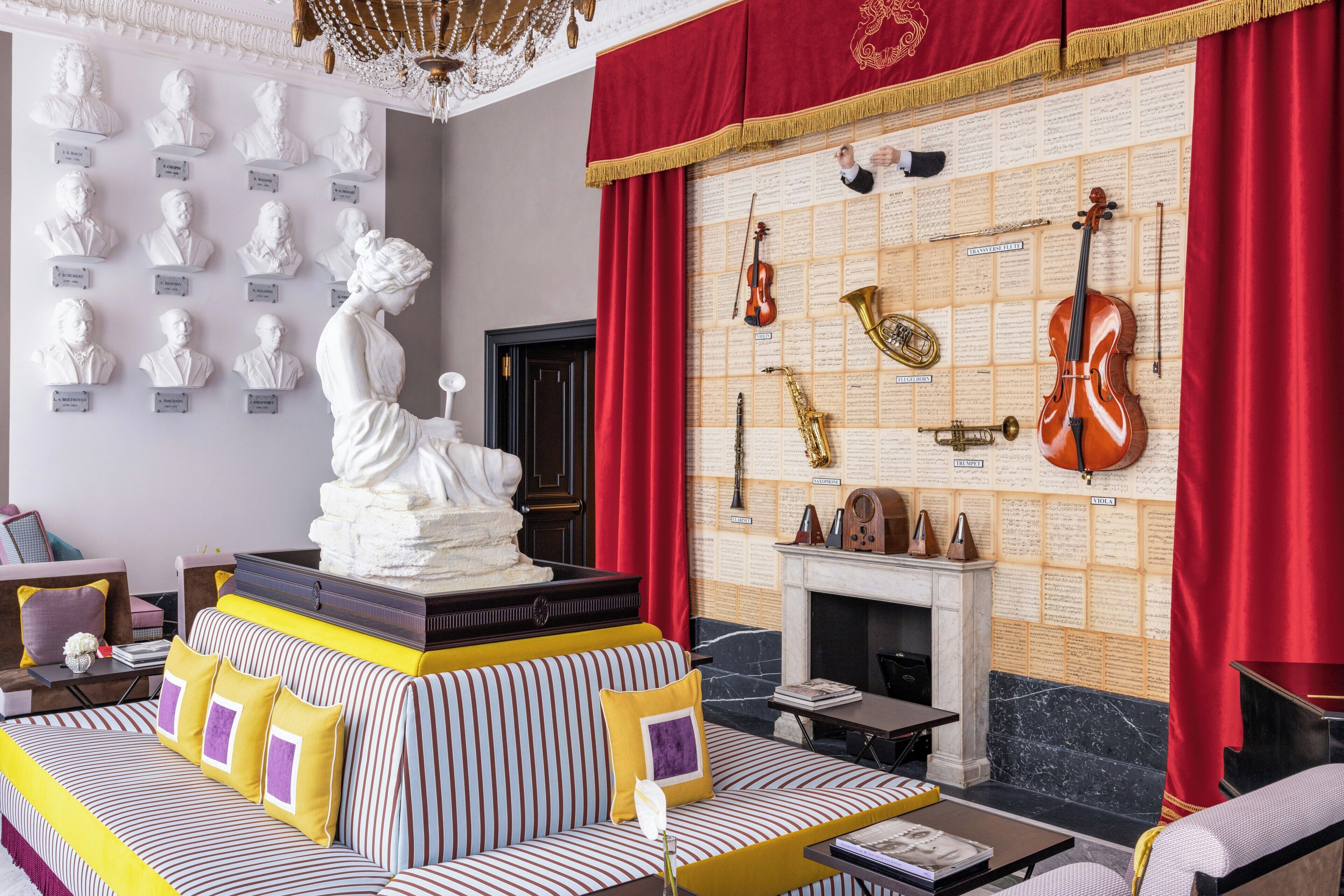 A room with a fireplace, a statue, and a wall of musical instruments.