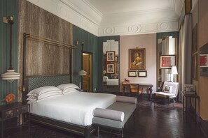 A hotel room with a large bed, a desk, a chair, and a painting on the wall. - Palazzo Roma (Rome)