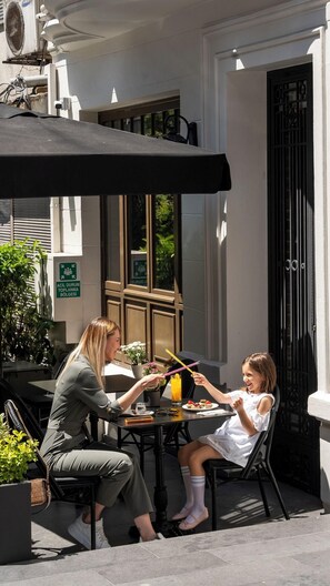 An outdoor café with a table, chairs, and a black umbrella. - Nex Hotel Istanbul City Center (Istanbul)
