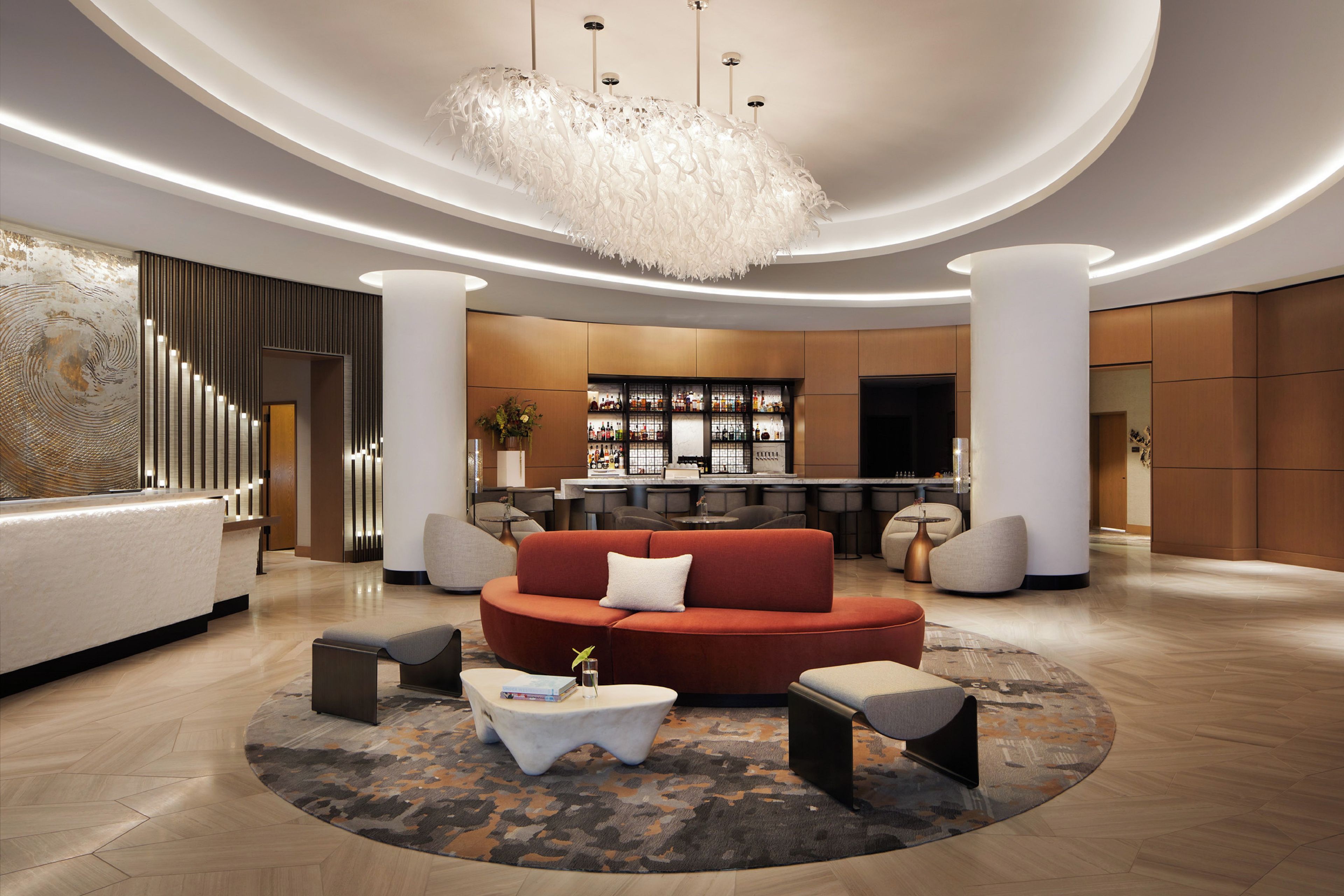 Een moderne lobby met een centrale zithoek, een bar en een receptiebalie.