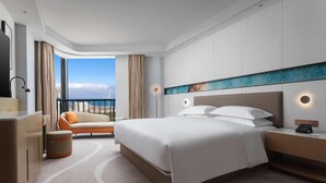 Habitación de hotel moderna con una cama grande, un escritorio, un sofá y vistas a la ciudad.