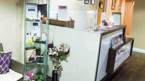 A reception area with a glass display case containing various items, a reception desk, and framed pictures on the wall. - Bells Hotel (Coleford)