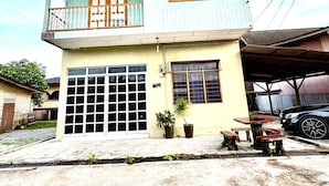 A two-story house with a balcony, a garage, and a small outdoor seating area. - Homestay Selesa KBB 2 Guest House (Kuala Terengganu)