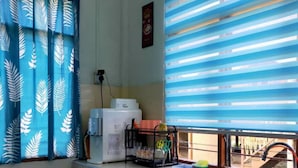 A kitchen with a window, a sink, and a countertop with various items. - Homestay Selesa KBB 2 Guest House (Kuala Terengganu)