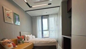 A modern bedroom with a bed, a sofa, a glass coffee table, and a large window. - The Bayment Residence (Busan)