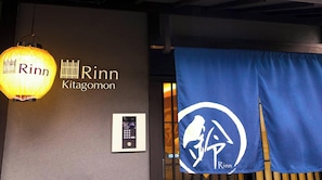 Seinässä on nimi «Rinn Kitagomon» ja sininen banneri, jossa on logo.