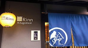 En væg med navnet 'Rinn Kitagomon' og et blåt banner med et logo.
