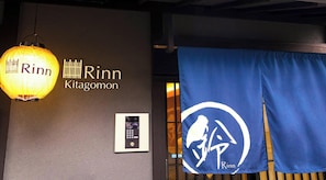 A wall with the name 'Rinn Kitagomon' and a blue banner with a logo.