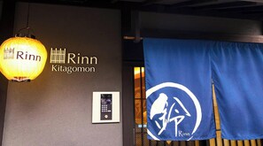 En vägg med namnet ”Rinn Kitagomon” och en blå banner med en logotyp.