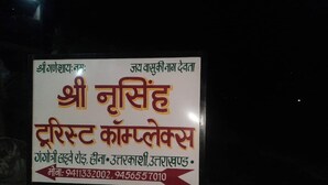 Un panneau indiquant le nom d’une entreprise et ses numéros de téléphone, le texte étant écrit en hindi.