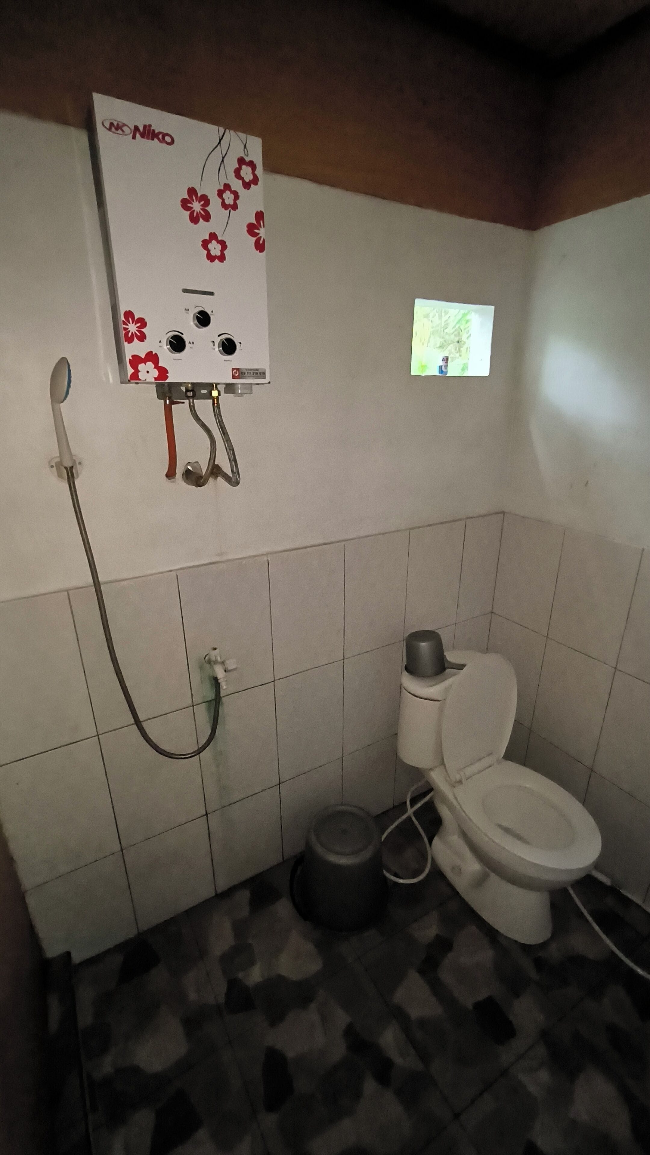 Pieni kylpyhuone, jossa on wc, bidee ja vedenlämmitin.
