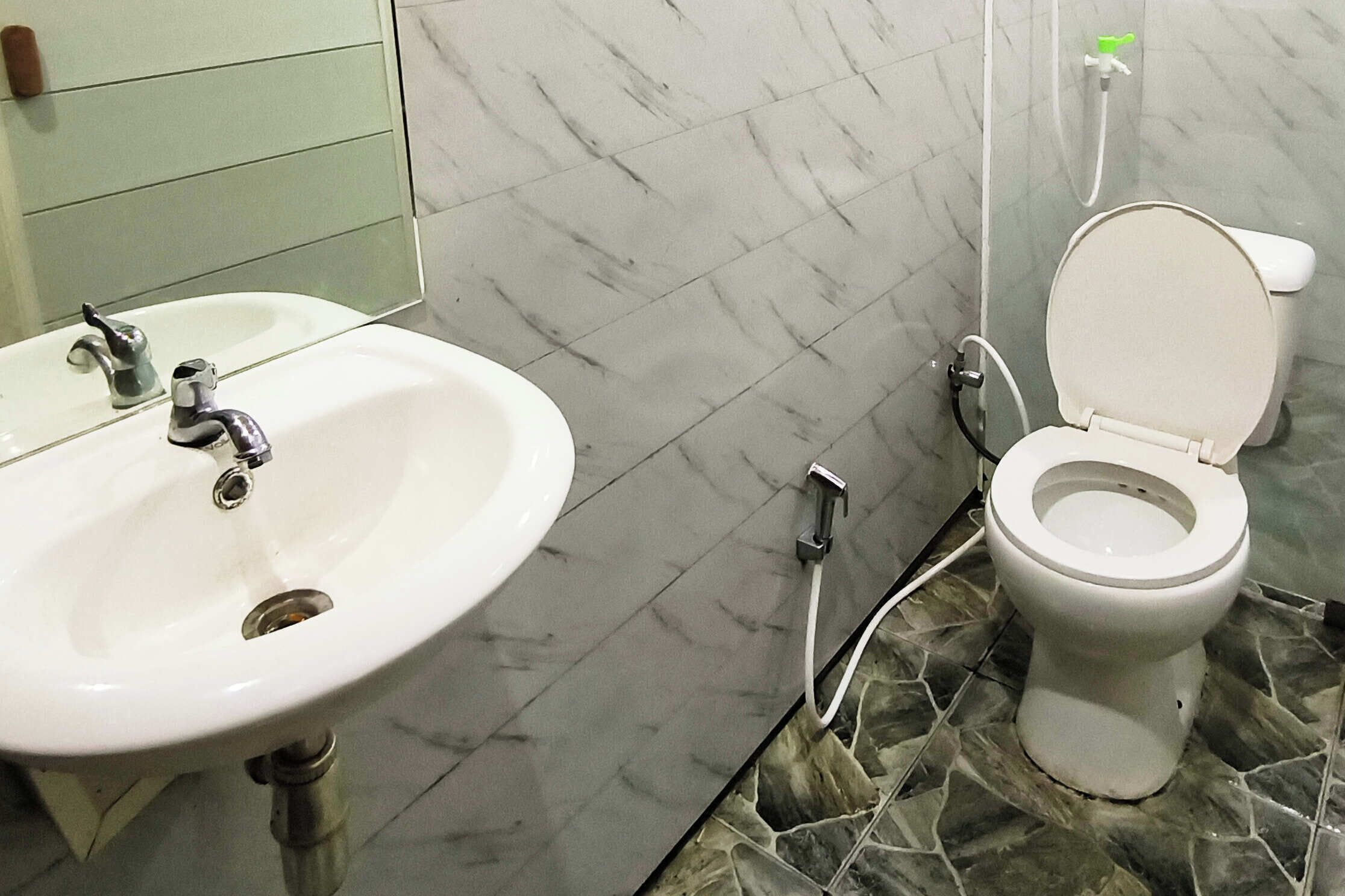 Un baño con un lavamanos blanco, un inodoro y una ducha.