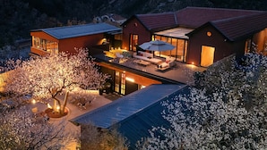 A modern house with a large patio area, surrounded by mountains. - TOPSCAPE Yangshan Hotel (Qingdao)