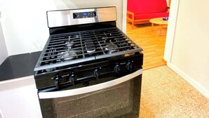 Uma cozinha compacta com micro-ondas integrado e fogão a gás.