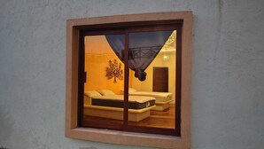 Een kamer met een bed, nachtkastje en een wandlamp.