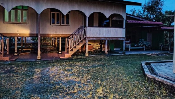 A two-story building with a balcony and a covered porch area.