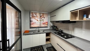 A modern kitchen with a built-in stove, a sink, and a window with a view. - Parkview Cribs. Serene 3BR with a DSQ near JKIA and SGR with National park view. (Nairobi)