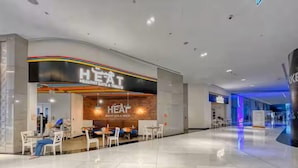 A modern restaurant with a clean, minimalist design, featuring a prominent 'HEAT' sign and a variety of seating options. - Vogue Park Tower DIFC  (Dubai)