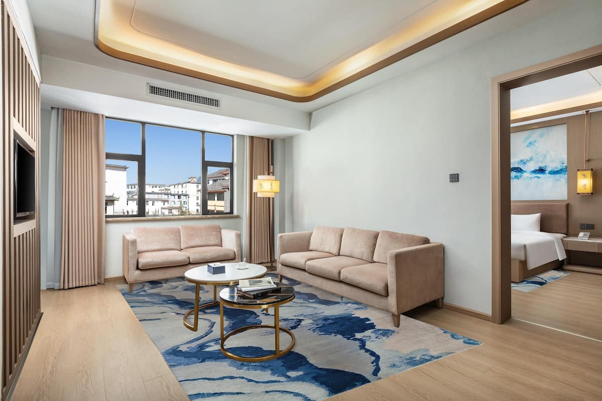 Una habitación de hotel moderna con un sofá, una mesa de centro y una cama.
