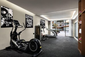 Un gimnasio moderno con bicicletas estáticas, una cinta de correr y una máquina de remo.