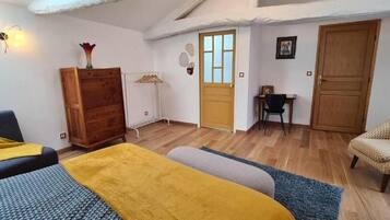 A bedroom with a bed, a wardrobe, a desk, and a chair.