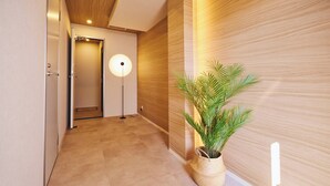 A hallway with a wooden floor, a potted plant, and a modern light fixture. - 2026/1/6 New open! Lux Villa(112 ㎡) 6 min Shinjuku/10 min Shibuya (Wakaba, Shinjuku-ku)