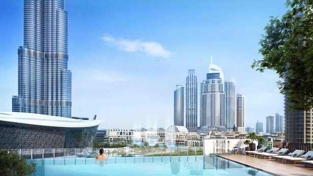 A modern hotel with a rooftop infinity pool overlooking a city skyline, featuring high-rise buildings and a distinctive architectural structure.