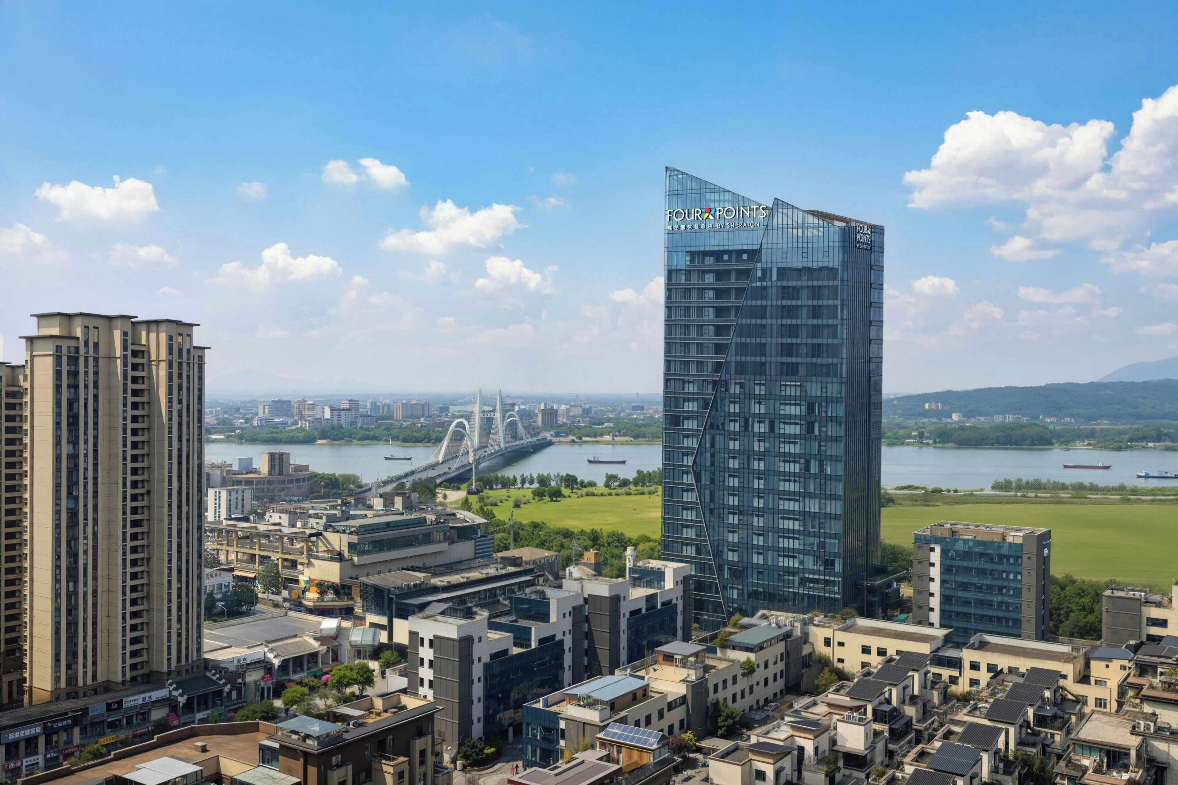 A cityscape with modern buildings, a river, and a bridge.
