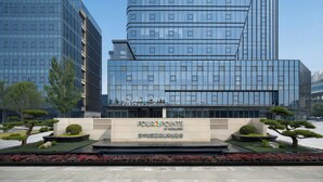 A modern hotel with a glass facade, a landscaped garden, and a sign indicating 'FOUR POINTS BY SERATON.' - Four Points by Sheraton Hanzhong Riverside (Hanzhong)