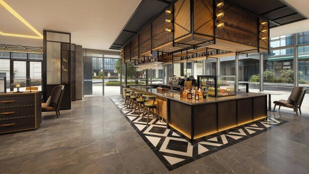 A modern bar area with a long counter, bar stools, and a decorative ceiling. - Four Points by Sheraton Hanzhong Riverside (Hanzhong)