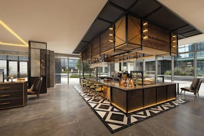 A modern bar area with a long counter, bar stools, and a decorative ceiling.