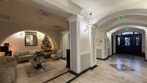 A lobby with a Christmas tree, sofas, and a grand entrance. - Hotel Iosefin Residence (Timișoara)
