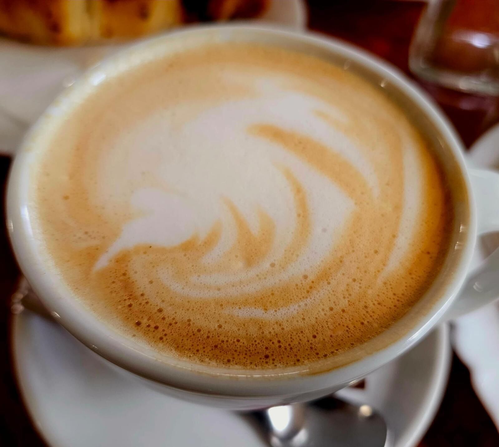 Eine Tasse Kaffee mit Latte-Art auf einem Untertasse.
