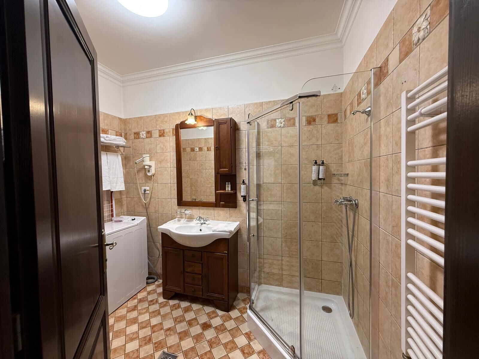 A bathroom with a shower, sink, and cabinet.