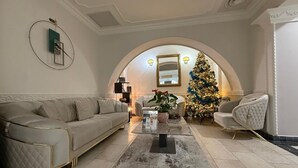 A living room with a beige sofa, a coffee table, and a Christmas tree. - Hotel Iosefin Residence (Timișoara)