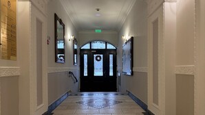 A hotel corridor with a check-in counter, a reception desk, and a door with a wreath. - Hotel Iosefin Residence (Timișoara)